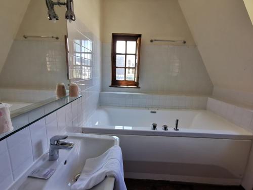 a white bathroom with a tub and a sink at Hotel La Résidence Manoir De La Salamandre in Étretat