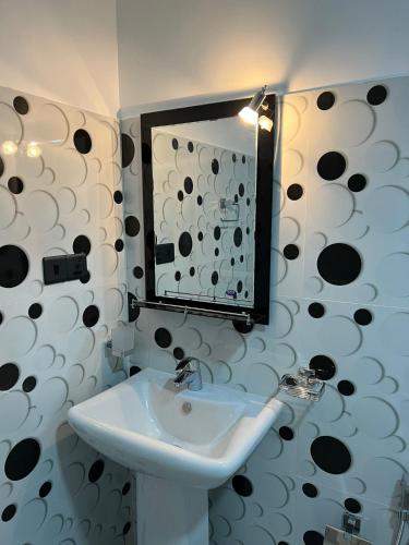 a bathroom with a sink and a mirror at Indika's Apartment in Hikkaduwa