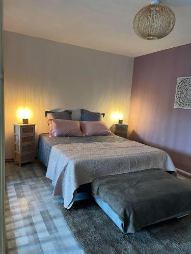- une chambre avec un lit avec des oreillers roses et 2 lampes dans l'établissement Gîte Les Lauriers, à Colmar