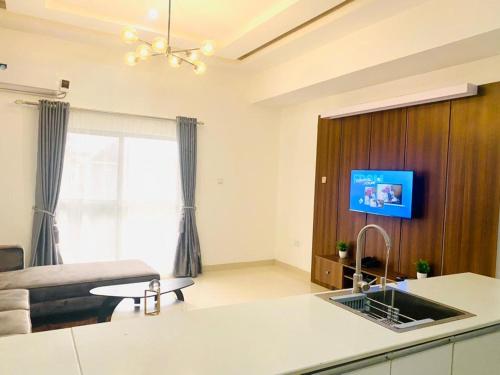 a kitchen with a sink and a tv in a room at Luxury Comfortable One Bedroom In Lekki Phase1 in Lekki