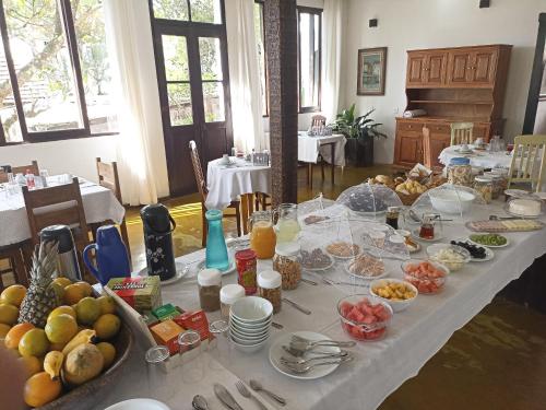 a long table with many plates of food on it at Cama e Café Tiradentes in Tiradentes