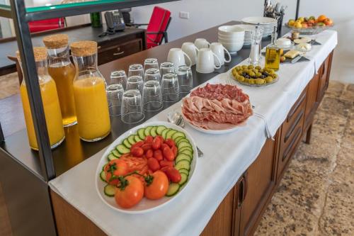 a buffet with plates of fruits and vegetables on a counter at Mosta Dome B&B in Mosta