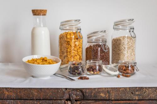 a table with jars of food and a bowl of cereal at Mosta Dome B&B in Mosta