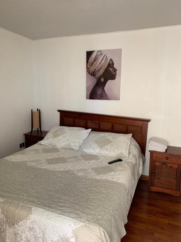 a bed in a bedroom with a picture on the wall at Campanario 104 con factura in Iquique