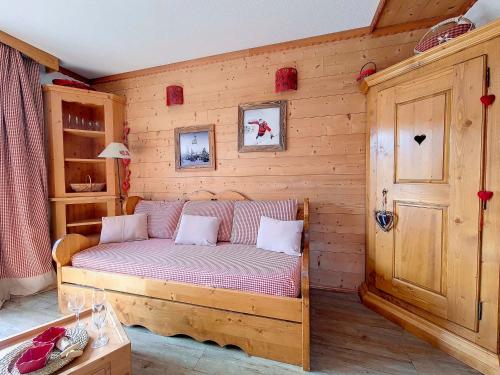 a bedroom with a bed in a wooden wall at Appartement Les Menuires, 2 pièces, 4 personnes - FR-1-344-867 in Les Menuires