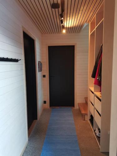 a hallway with a black door and a closet at Huset ved skogen in Isfjorden