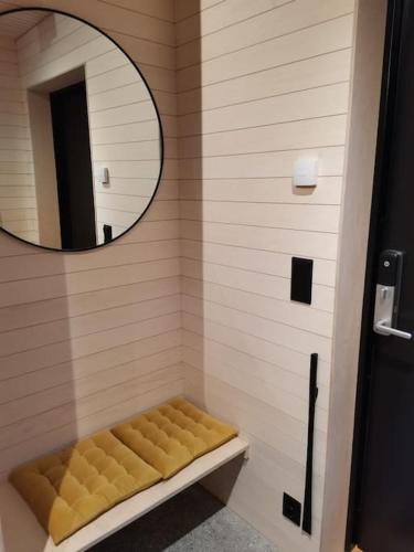 a bathroom with a mirror and a bench in a shower at Huset ved skogen in Isfjorden