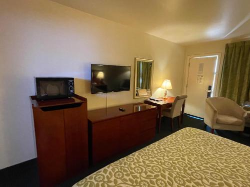 a hotel room with a bed and a flat screen tv at Days Inn by Wyndham Deming in Deming