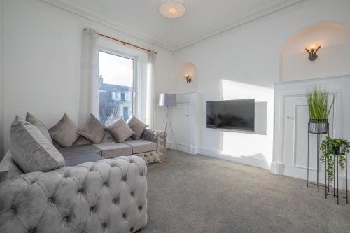 uma sala de estar com um sofá e uma janela em Brulee House - Luxury 2 Bed Apartment in Aberdeen Centre em Aberdeen