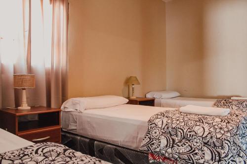 卡法亞特的住宿－EL PEDREGAL Casa en Cafayate，酒店客房设有两张床和窗户。