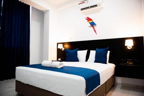 a bedroom with a large bed with blue and white pillows at Hotel Boutique Papagayo in Tarapoto