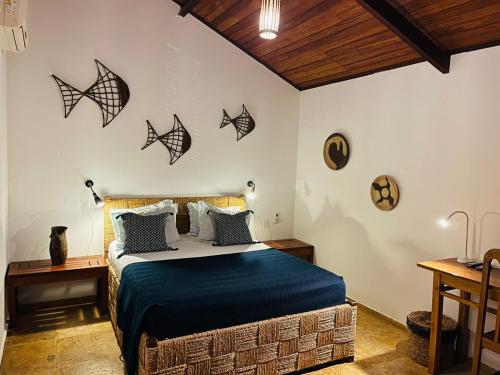 a bedroom with a bed with black bats on the wall at Torre de Chocolate Pousada in Barra Grande