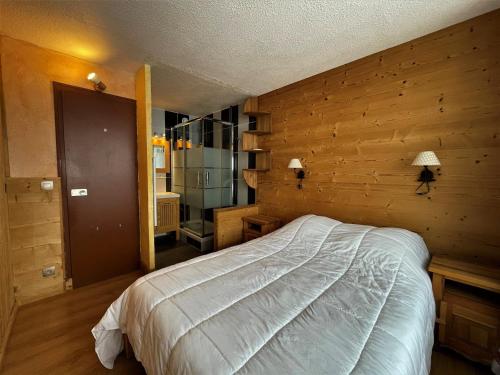 レ・メニュアールにあるAppartement Les Menuires, 2 pièces, 4 personnes - FR-1-452-177の木製の壁のベッドルーム1室(ベッド1台付)