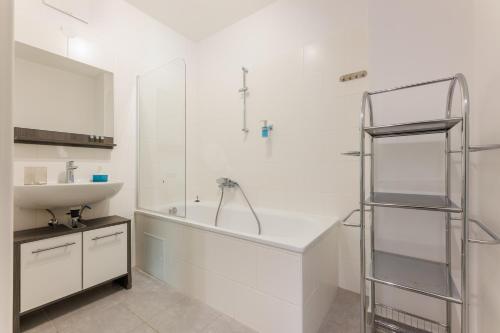 een witte badkamer met een wastafel en een douche bij Home in Vienna by Oberlaa Therme - 15 min to the city center in Wenen
