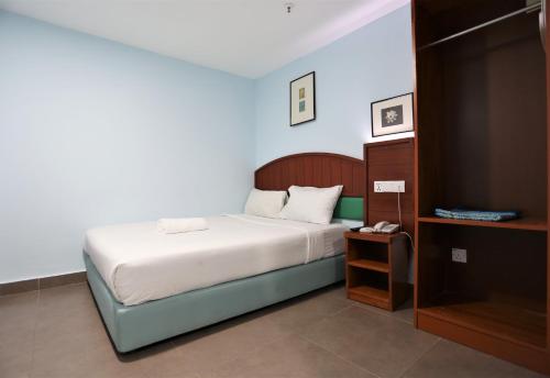 a small bedroom with a bed and a night stand at Orkid Hills Hotel in Kuala Lumpur