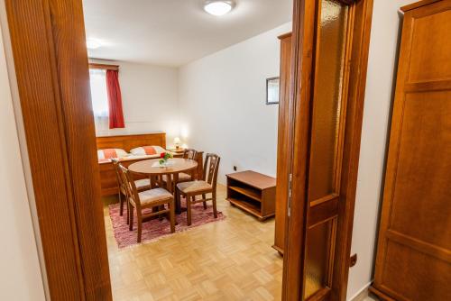 a room with a table and chairs and a bedroom at Apartments Galunder in Veržej