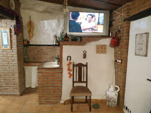 sala de estar con TV en la pared en El Río, en Dúrcal