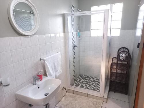 a bathroom with a shower and a sink at Elegant 1-Bedroom Apartment with pool. in Richards Bay