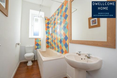 a bathroom with a sink and a toilet and a mirror at Dwellcome Home Ltd 3 Double Bedroom Aberdeen Apartment - see our site for assurance in Aberdeen