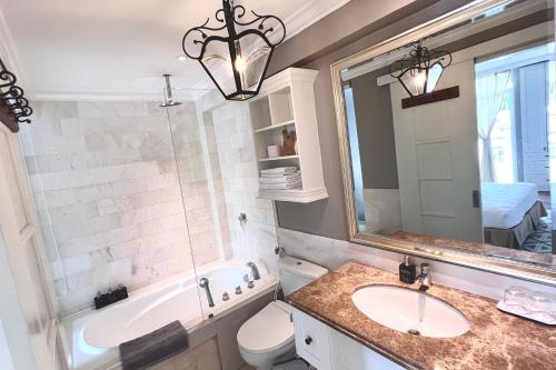 a bathroom with a sink and a tub and a mirror at HOME by FLATTO APARTMENT in Ho Chi Minh City