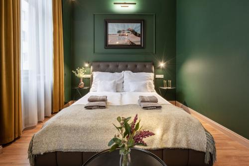 a green bedroom with a large bed with a table at The Pearl of the Heart of Budapest in Budapest