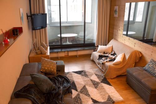 - un salon avec un canapé, des chaises et une fenêtre dans l'établissement Studio confort, Front de neige, Parking gratuit, à Isola 2000