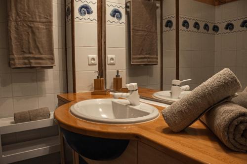 La salle de bains est pourvue d'un lavabo, d'un miroir et d'une baignoire. dans l'établissement Studio confort, Front de neige, Parking gratuit, à Isola 2000