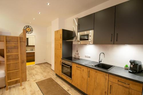 a kitchen with wooden cabinets and a sink at W-Spirit Apartments in Jerzens