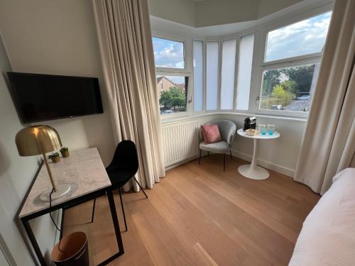 a hotel room with a bed and a table and a window at Tuss in Kortrijk