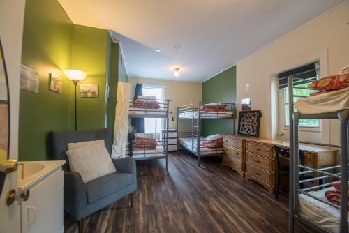a room with bunk beds and a couch and a chair at Auberge du Monde in Trois-Rivières