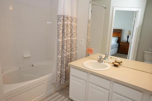 a bathroom with a sink and a tub and a shower at Windsor Hills Resort- 7682 Sir Kaufmann in Orlando