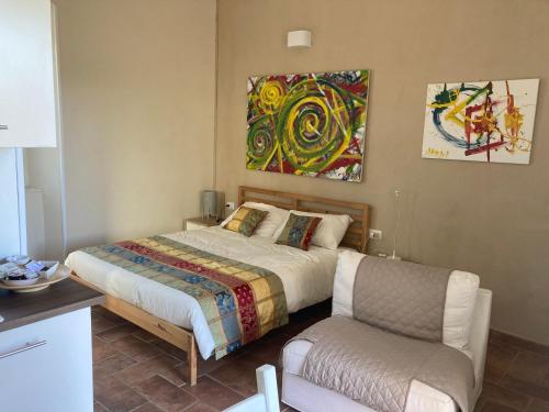 um quarto com uma cama, uma cadeira e um quadro em Borgo Bruno em Ceprano