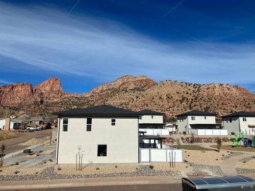 a white building with a mountain in the background at Water Canyon 4bd3Bath HotTubDeck in Hildale