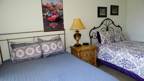 a bedroom with two beds and a lamp on a night stand at Windsor Hills Resort- 205 in Orlando