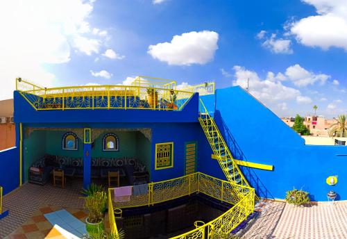 ein blaues Gebäude mit einer gelben Treppe davor in der Unterkunft Hotel Medina in Marrakesch