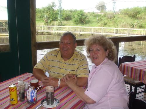 um homem e uma mulher mais velhos sentados à mesa em Bienvenue Self Catering em Mossel Bay