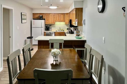 a kitchen with a wooden table with chairs and a refrigerator at Hike, Ski, Explore Lincoln Condo with Pool Access in Lincoln
