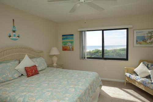 1 dormitorio con cama, ventana y sofá en Canaveral Towers Oceanfront 402!, en Cabo Cañaveral