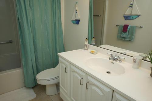 a bathroom with a sink and a toilet and a shower at Canaveral Towers Oceanfront 402! in Cape Canaveral