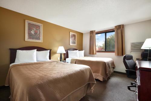 a hotel room with two beds and a window at Travelodge by Wyndham La Porte/Michigan City Area in LaPorte