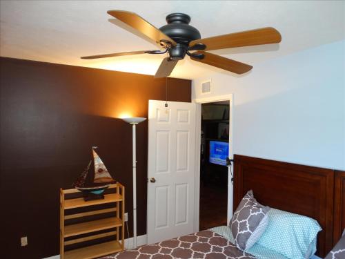 a ceiling fan in a bedroom with a bed at Quiet Vista Del Mar 2 Bedroom Condo Beachfront Property in Cocoa Beach