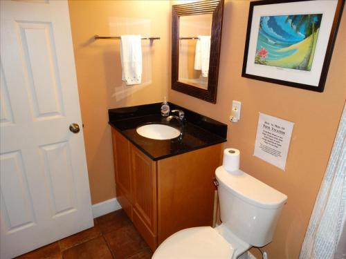 a bathroom with a toilet and a sink and a mirror at Quiet Vista Del Mar 2 Bedroom Condo Beachfront Property in Cocoa Beach
