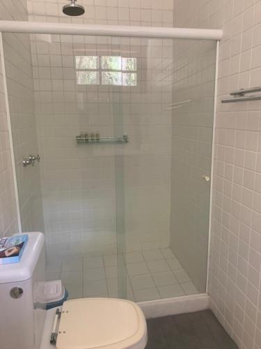 a bathroom with a shower with a toilet and a sink at Casa Riacho Verde in Petrópolis