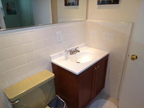 a bathroom with a sink and a toilet and a mirror at Spanish Main Unit 4- Direct Oceanfront Condo! in Cocoa Beach