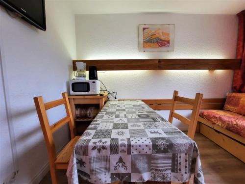 Cette petite chambre comprend une table et un four micro-ondes. dans l'établissement Studio 2 pers - Ski aux pieds, balcon, centre Menuires - FR-1-452-216, aux Menuires