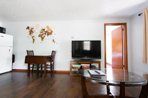 a living room with a table and a flat screen tv at Cozy 1 Bedroom Unit - 4 Blocks from Jax Beach Pier! in Jacksonville Beach