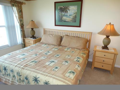 een slaapkamer met een bed en twee nachtkastjes met lampen bij Spanish Main 66- Direct Oceanfront Condo! in Cocoa Beach