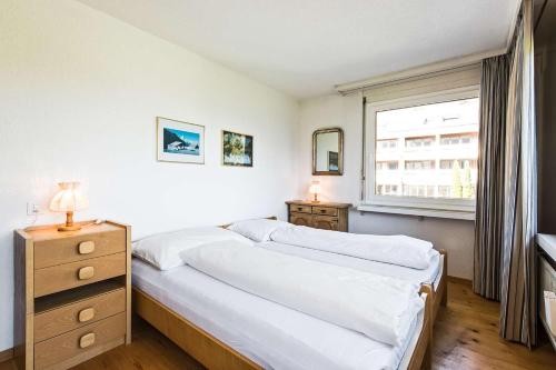 een slaapkamer met 2 bedden en een raam bij Quadern Apartmenthaus B204 in Bad Ragaz