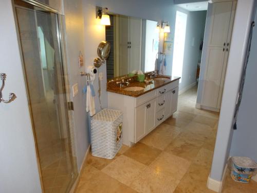 a bathroom with a sink and a glass shower at 3800 Ocean Blvd Luxury 501- Direct Oceanfront Condo! in Cocoa Beach