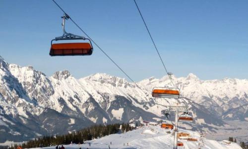 a ski lift with snow covered mountains in the background at Pöchtlhof in Leogang